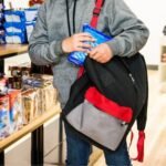 an-eleven-year-old-child-stealing-cookies-in-store-he-is-sliding-a-bag-of-cookies-or-treats-into-his.jpeg