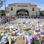 epa12606255-mourners-place-flowers-at-a-memorial-at-bondi-beach-in-sydney-australia-21-december-2025.webp