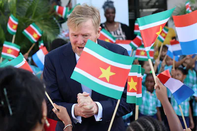 the-netherlands-king-willem-alexander-greets-people-among-surinamese-and-dutch-flags-during-an-offic.webp