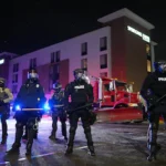 law-enforcement-officers-stand-during-a-protest-outside-springhill-suites-and-residence-inn-by-marri.webp