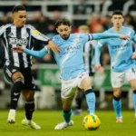 newcastle-s-jacob-ramsey-left-fights-for-the-ball-with-manchester-city-s-bernardo-silva-during-the-e.webp