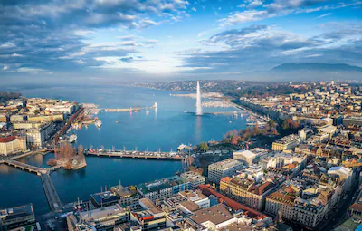 aerial-view-of-the-cityscape-and-lake-geneva-switzerland-during-a-sunny-winter-day-with-fog-clouds-a.webp