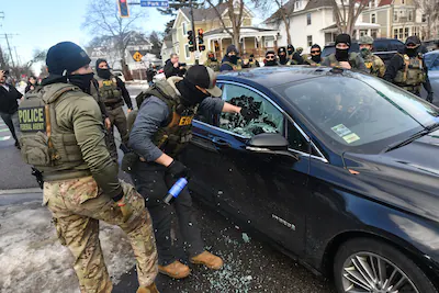 ice-and-other-federal-officers-break-a-car-window-as-they-begin-the-process-of-removing-a-woman-from.webp