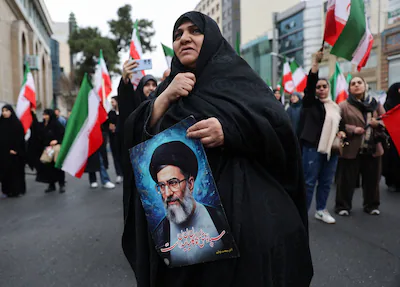 a-woman-holds-an-image-of-iran-s-supreme-leader-ayatollah-ali-khamenei-as-iranian-demonstrators-prot.webp
