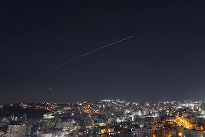 rocket-trails-are-seen-in-the-sky-above-the-city-of-hebron-in-the-israeli-occupied-west-bank-amid-a.webp
