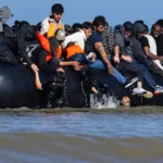 files-migrants-try-to-board-a-smuggler-s-boat-in-an-attempt-to-cross-the-english-channel-off-the-bea.webp
