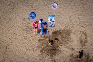 dronebeeld-van-de-reeuwijkseplassen-nabij-de-reeuwijksehout-mensen-zoeken-verkoeling-op-en-langs-het.jpeg