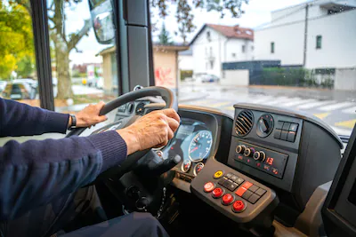 mature-man-driving-bus-in-city.webp