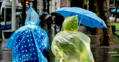 mensen-trotseren-de-regen-gehuld-in-poncho-en-gewapend-met-paraplu.webp