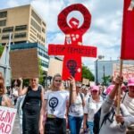 rotterdam-netherlands-2025-08-03-a-protester-holds-a-big-gender-symbol-of-women-with-words-stop-femi.jpeg