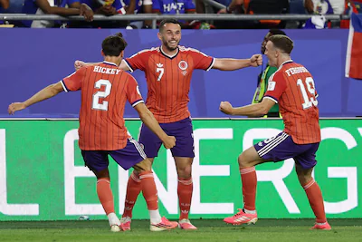 scotland-s-midfielder-07-john-mcginn-celebrates-with-teammates-defender-02-aaron-hickey-and-midfield.webp