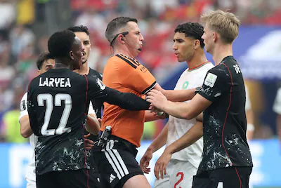 canada-s-defender-22-richie-laryea-and-morocco-s-defender-02-achraf-hakimi-argue-next-to-english-ref.webp