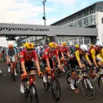 the-pack-of-riders-peloton-cycles-on-the-magny-cours-race-track-at-the-start-of-the-12th-stage-of-th.webp