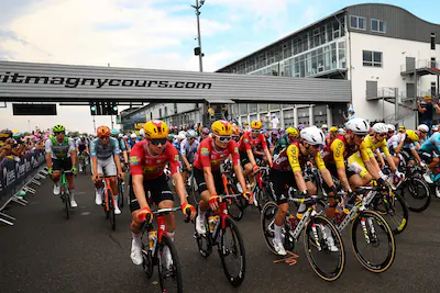 the-pack-of-riders-peloton-cycles-on-the-magny-cours-race-track-at-the-start-of-the-12th-stage-of-th.webp